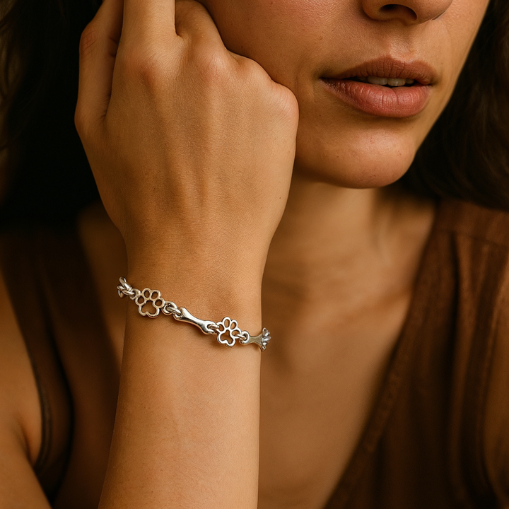 Silver bracelet with dog paw prints and a bone