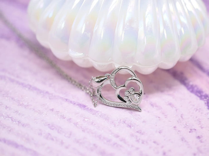 Silver necklace with a footprint and heart, set with zirconia.