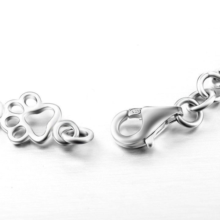 Silver bracelet with dog paw prints and a bone