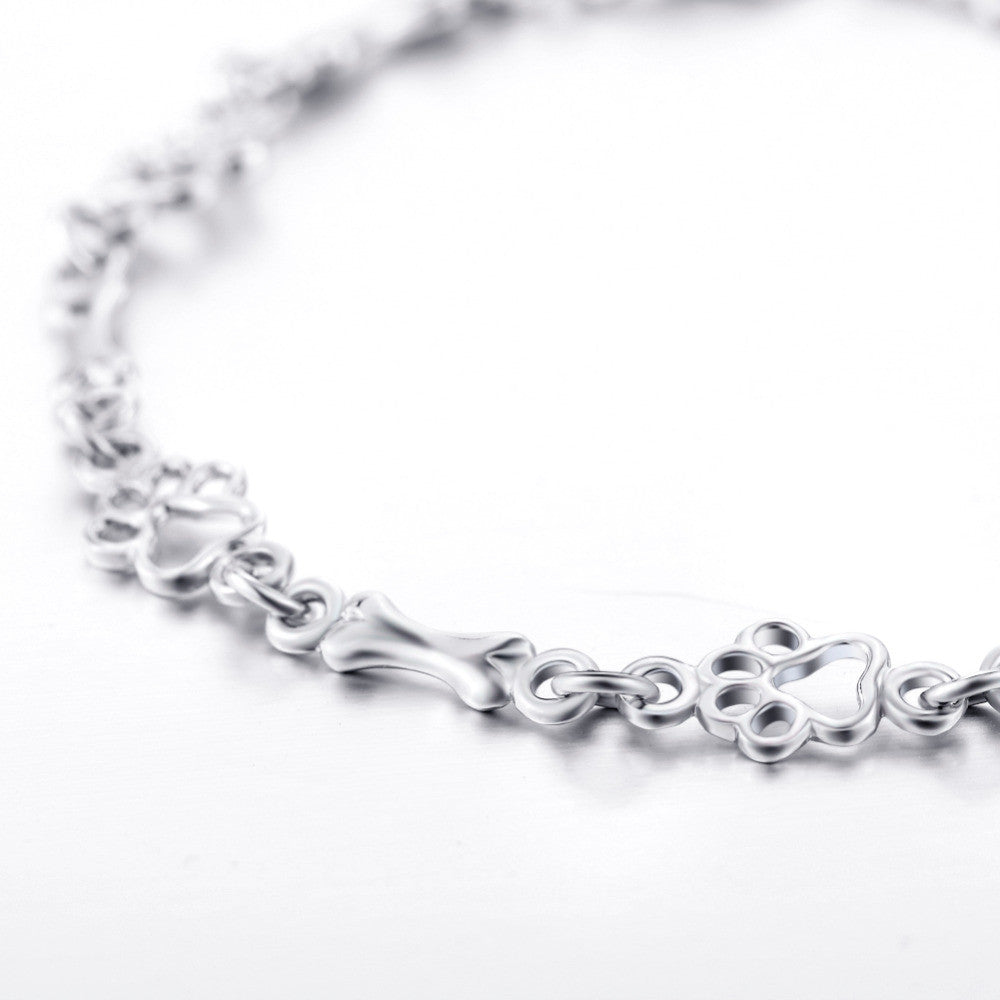 Silver bracelet with dog paw prints and a bone