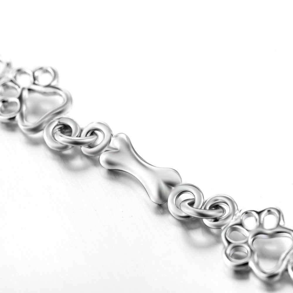 Silver bracelet with dog paw prints and a bone