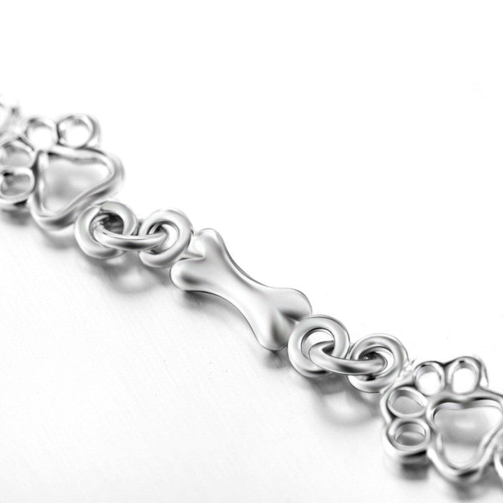 Silver bracelet with dog paw prints and a bone