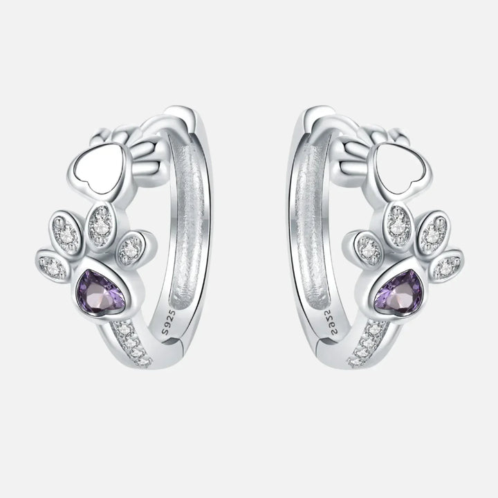 Silver paw print earrings with zirconia and a heart-shaped gemstone.